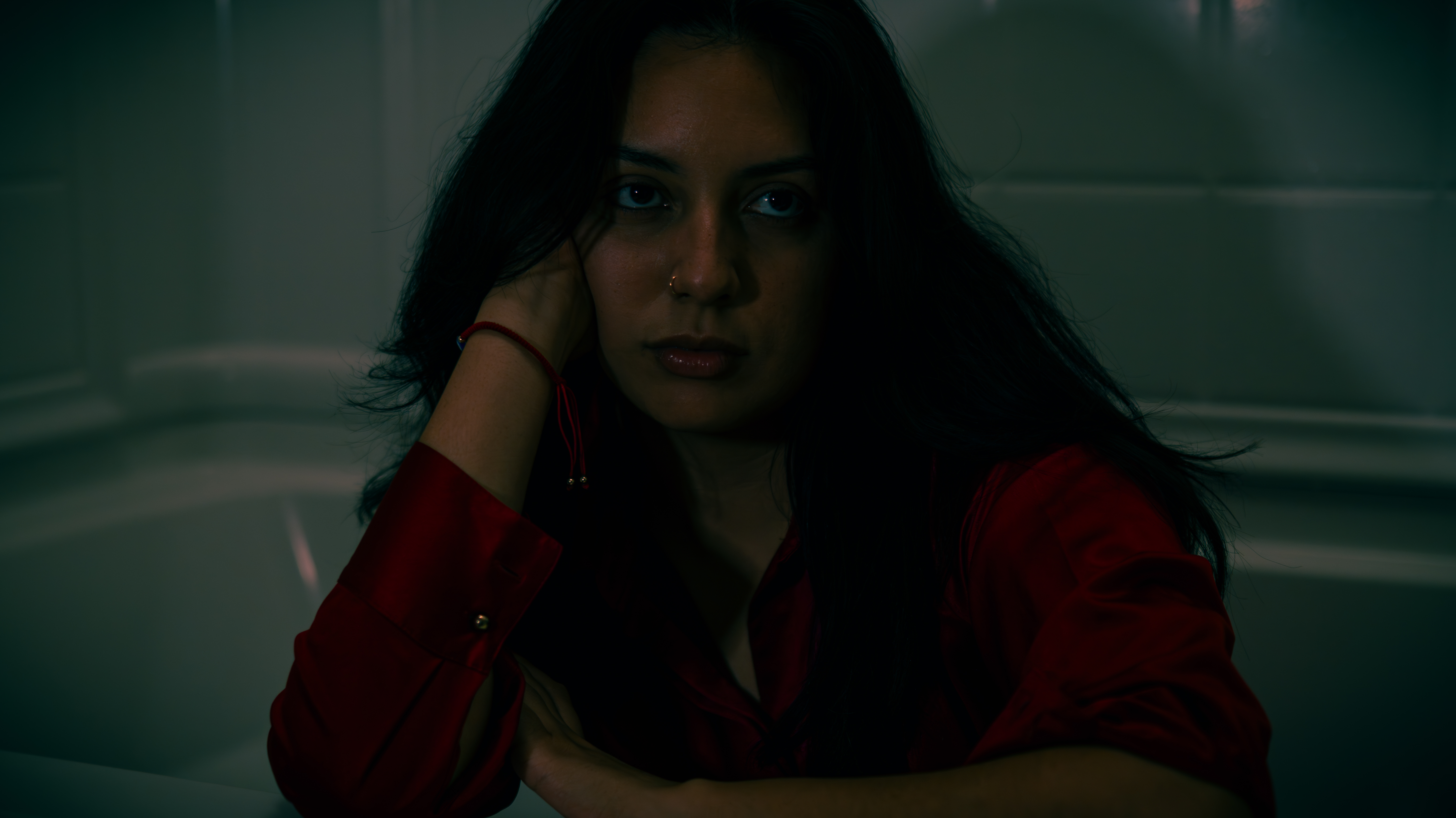 Woman wearing a red shirt in a bathtub
